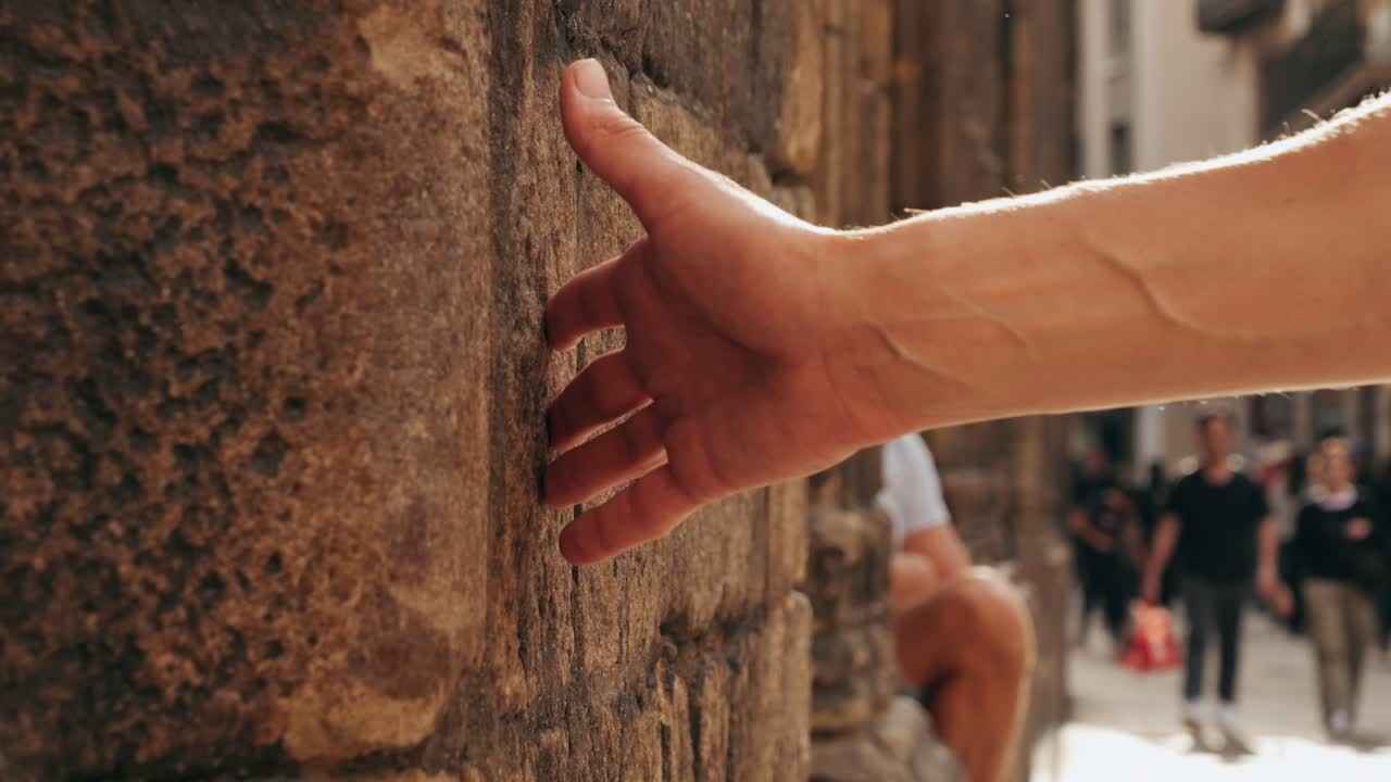Touching old castle wall, Happy tourist man in Barcelona, Spain. Vacation exploring interesting places to travel, student vacation, young man portrait walking in gothic square, old european city