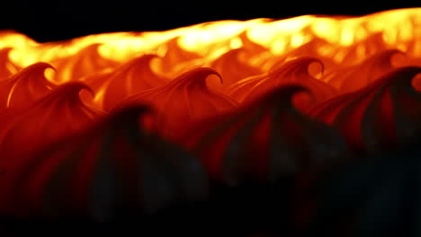 white marshmallows lit in orange in a drier machine. manufacturing sweet desserts at present day factory. close up. blurred background.