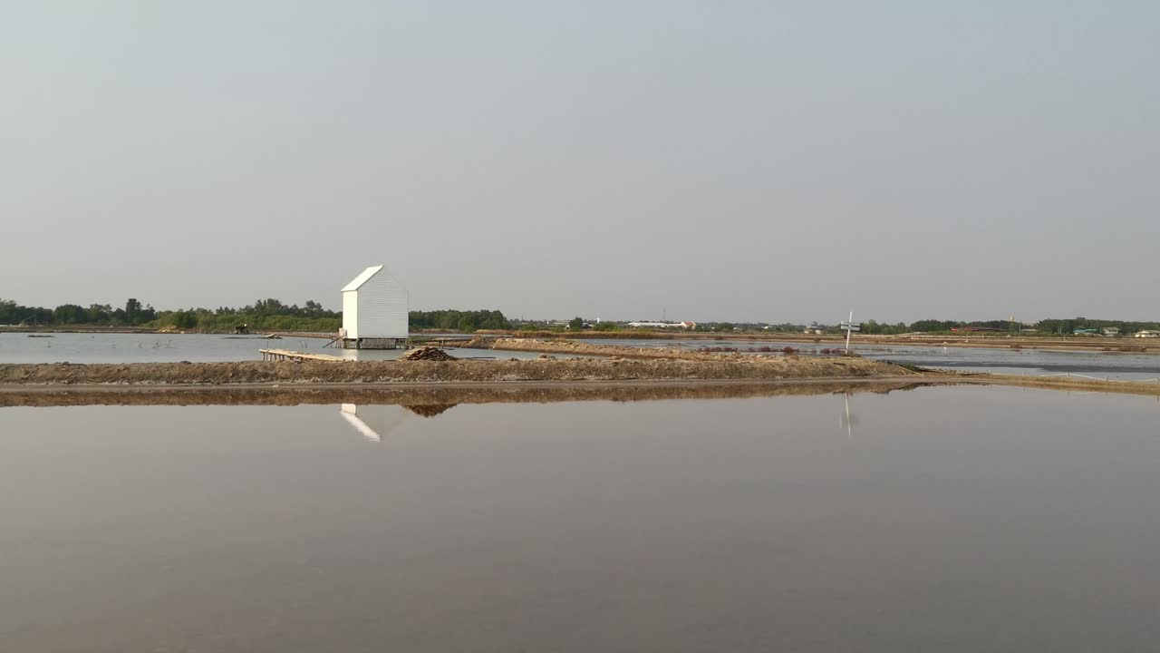 lago de sal en de maeklong cafetería y restaurante con un cobertizo de almacenamiento blanco sobre aguas poco profundas con reflejo en tailandia