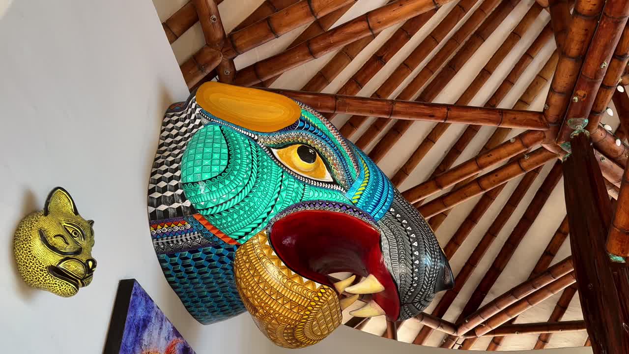Escultura de parede decorativa dentro de um interior de hotel, apresentando elementos de design coloridos e materiais naturais, frequentemente usada para ilustrar conceitos de hospitalidade, viagens e decoração de interiores