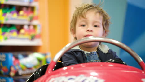 little boy swinging in a toy car