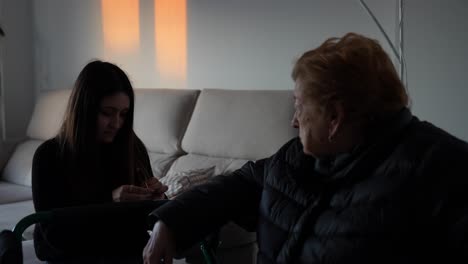 Grandmother watching granddaughter try new keyring at home in warm sunset light