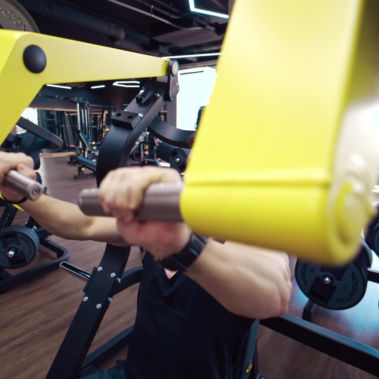 Muscular man exercising in gym. Athlete exercising using weight lifting machine to lose weight
