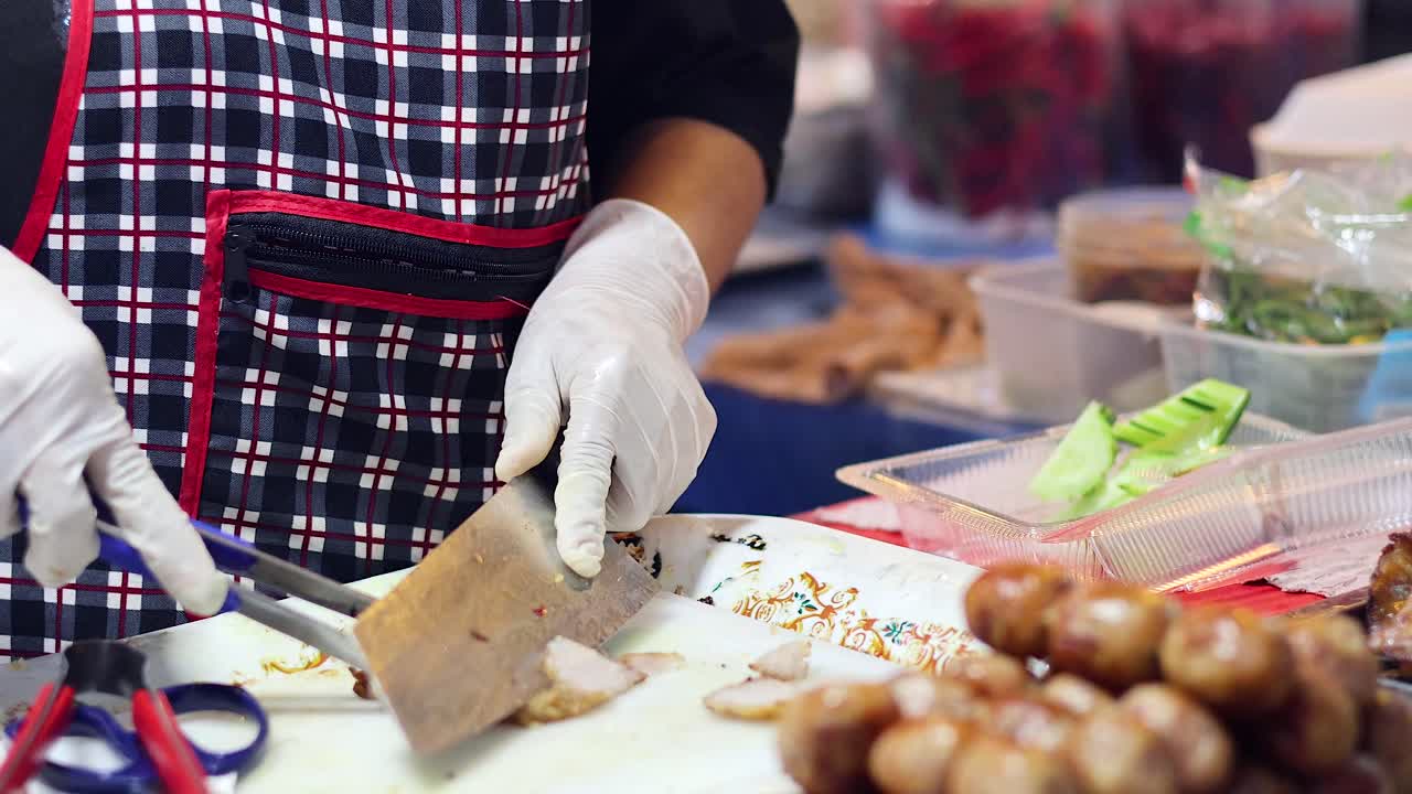 vendedor cortando carne de cerdo en el puesto del mercado nocturno