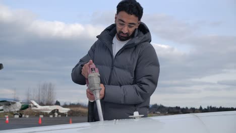 Portrait-of-Man-Fueling-Wing-of-an-Airplane-SLOMO