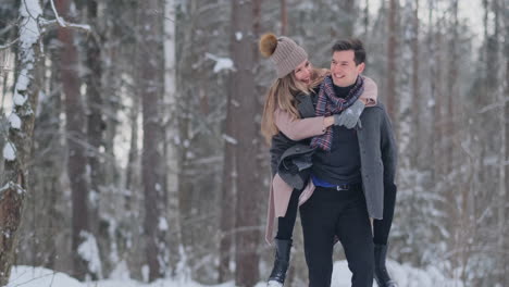 Happy-Couple-is-Playing-Winter-Game-Outside-Enjoying-Sunlight-and-Warm-Winter-Weather-in-the-Mountains.-Strong-Boy-is-Carrying-Girlfriend-on-His-Shoulders-and-Whirls-Her
