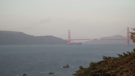 Cargo-Ship-Sails-Underneath-Golden-Gate-Bridge-on-a-Clear-Evening-In-San-Francisco