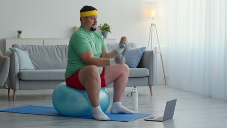 hombre trabajando en casa con pesas en la pelota de yoga