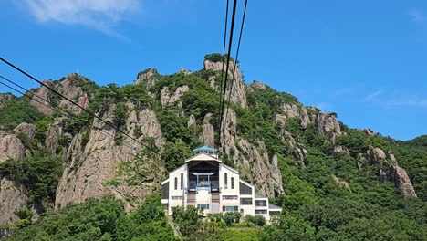 daedunsan cable car - pov from gondola arriving to destination building on mountain top, with a picturesque view of daedunsan clify summit, south korea