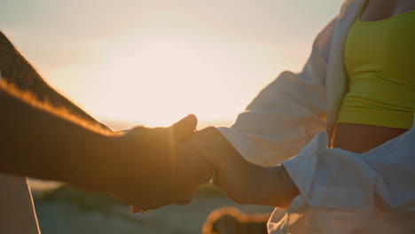 couple holding hands at sunset on the beach