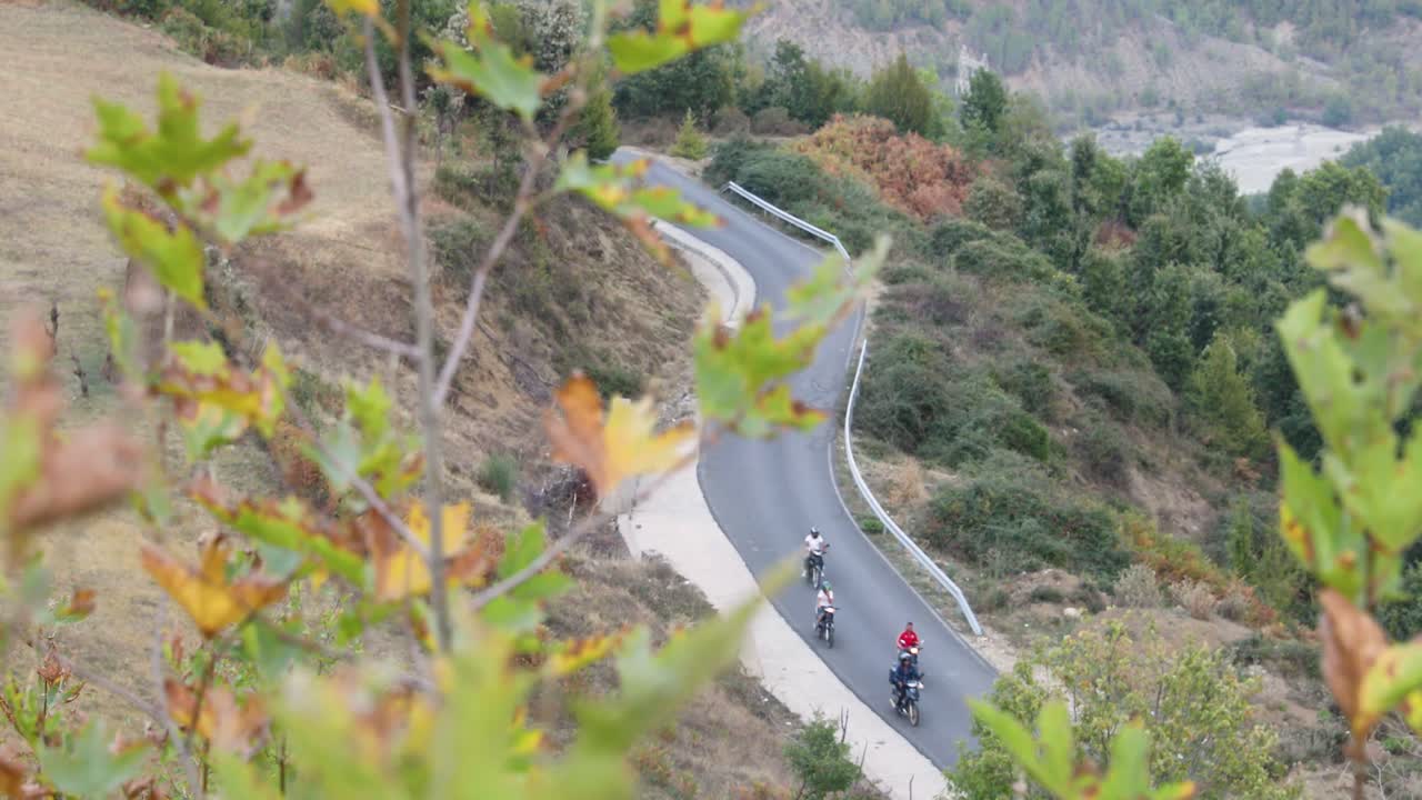 Asphalt road between the mountains. Motorcyclists on the road.