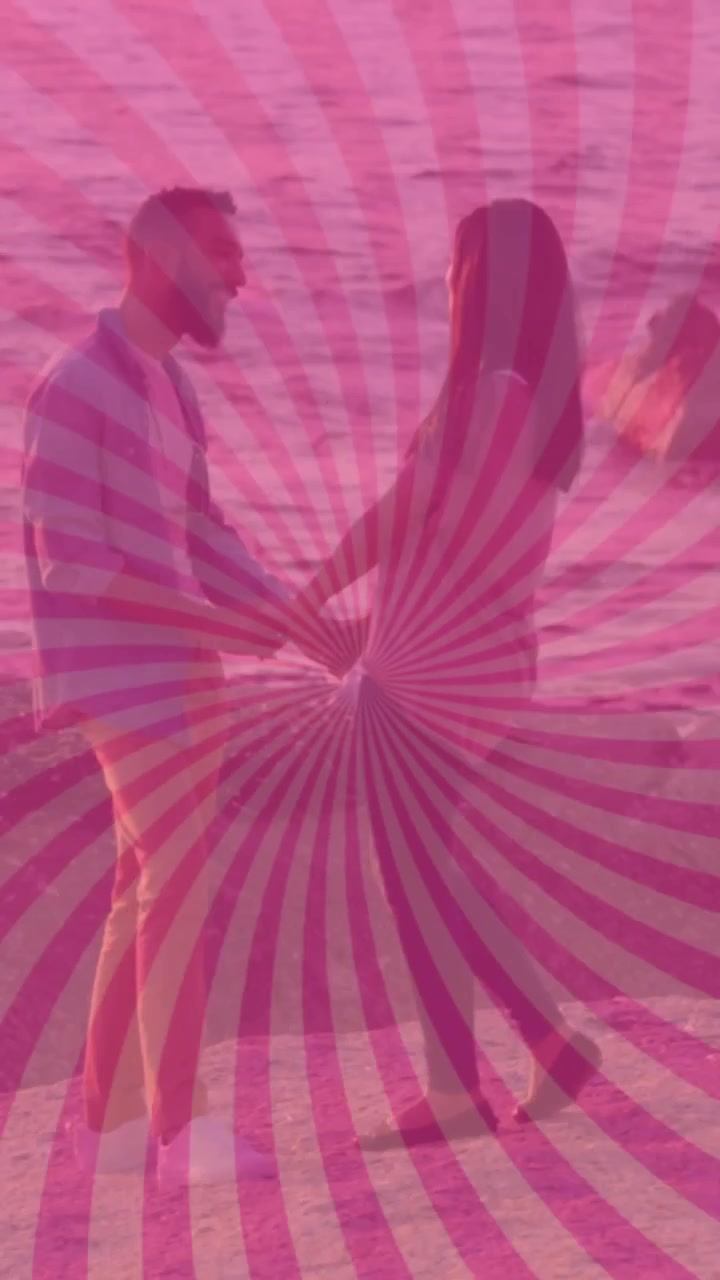 Animazione di un motivo a raggi di sole rosa su una coppia di diverse etnie che si tiene per mano e sta in piedi vicino al mare.