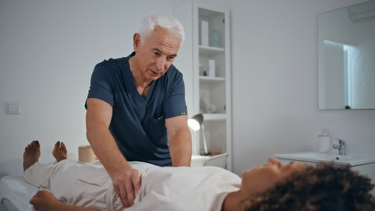 médico examinando el trauma del paciente en la clínica. terapeuta maduro hablando mujer