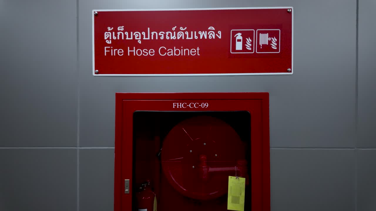 Fire hose cabinet with emergency equipment providing protection on a grey wall