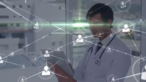 Animation-of-connected-people-icons-and-lens-flare-over-happy-caucasian-doctor-using-digital-tablet