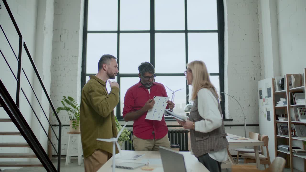 Gruppo di professionisti che discutono di un progetto di energia sostenibile in ufficio.