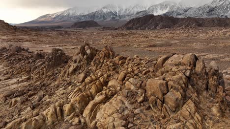 drone pan up of the alabama hills in california with the sierra mountains in the background