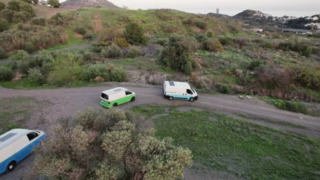 Discover-the-bustling-streets-of-Malaga,-Spain,-with-our-captivating-drone-footage-showcasing-three-white-vans-in-motion