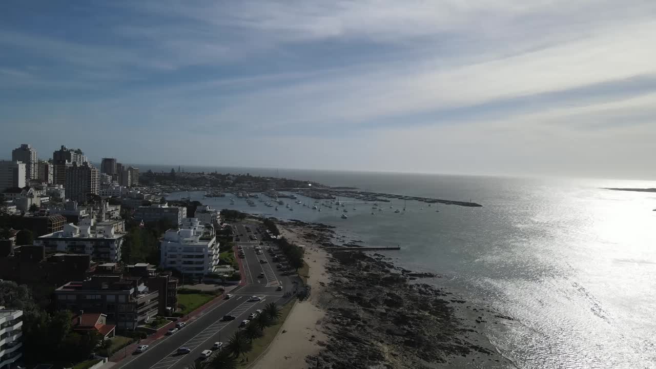 Aerial view of punta del este coastline in uruguay, featuring buildings, beach, ocean, and boats
