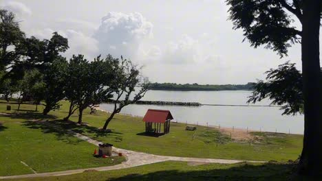 Sonniger-Meerblick-Mit-Kleinem-Pavillon,-Bäumen-Und-Wolken-Und-Auf-Einer-Tropischen-Insel