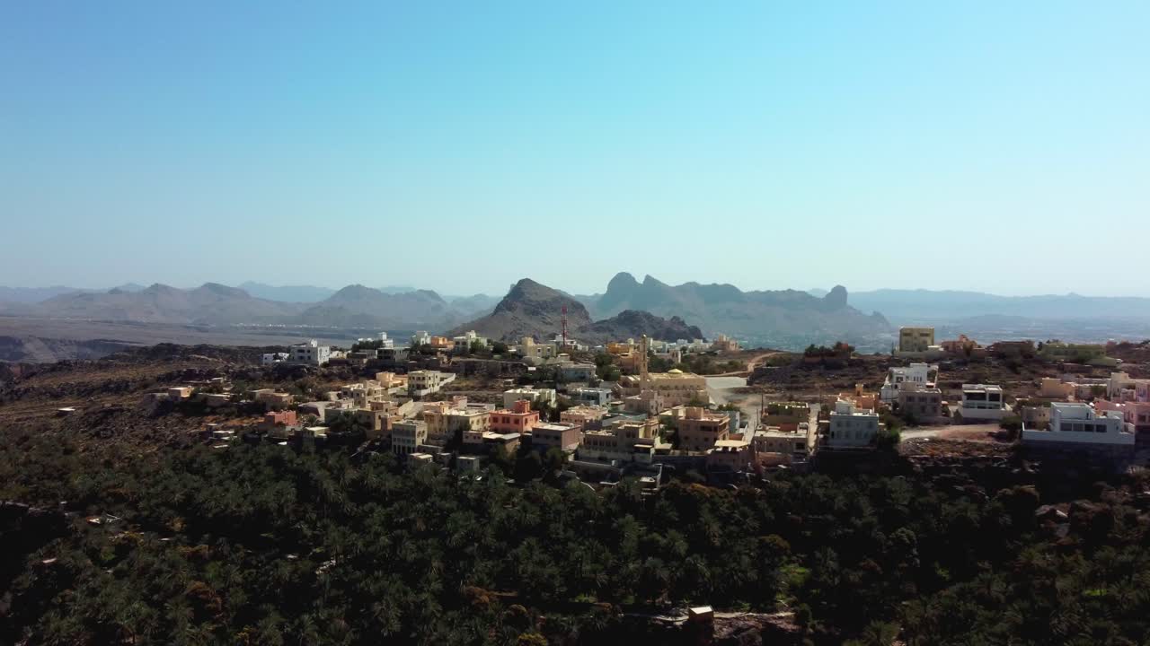 Veduta aerea di Misfat Al Abriyeen, Oman! Scopri case storiche in pietra, terrazzamenti e l'antico sistema falaj. Guarda ora!