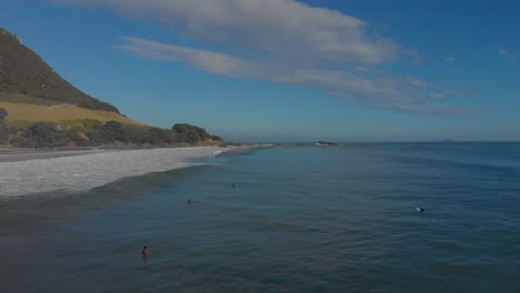 AERIAL:-Surfers-at-Mount-Maunganui-Beach,-New-Zealand