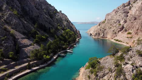 Crecientes-Tomas-De-Drones-De-Botes-De-Estacionamiento-En-La-Bahía-De-Zavratnica-Cerca-De-Jablanac-Con-Barco-Hundido-Durante-El-Día-Soleado-En-Croacia