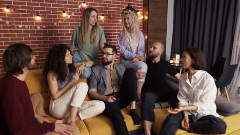 Group-of-happy-caucasian-men-and-women-in-conversation-on-sofa,-slow-motion