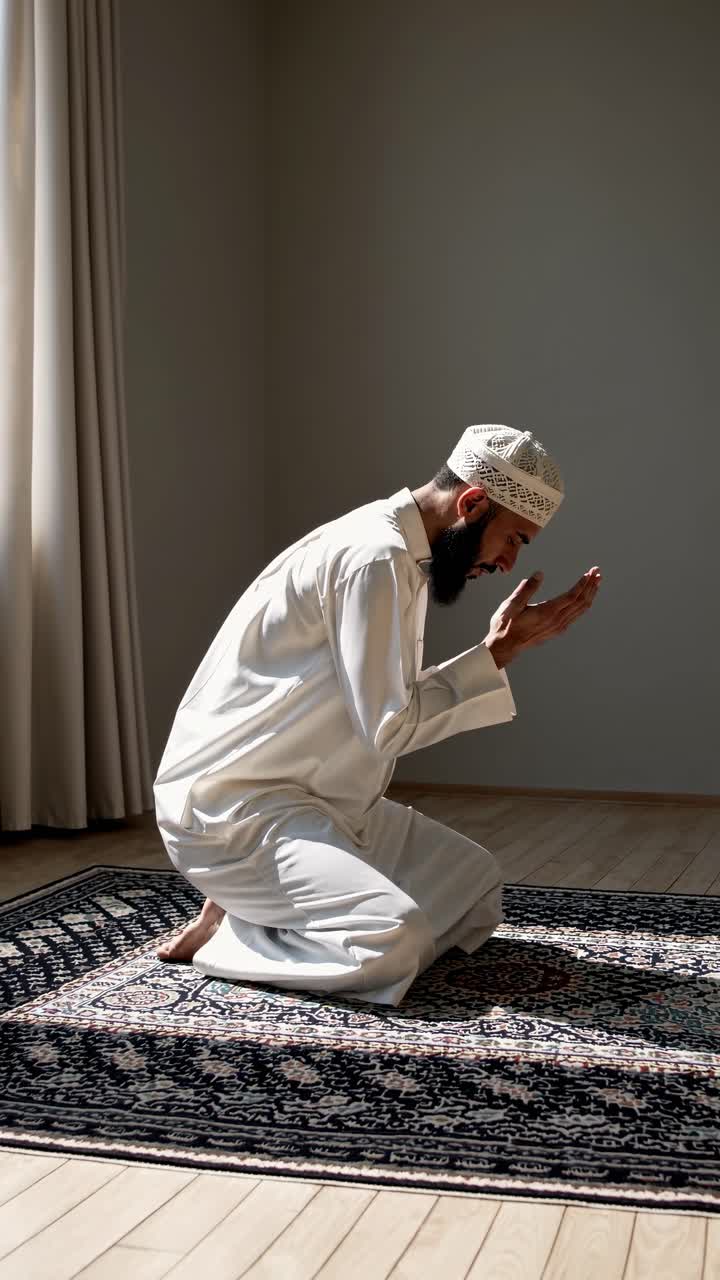 A serene video captures a man in traditional attire praying on a rug