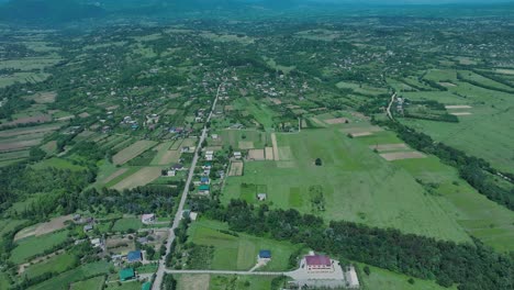 aerial view of a lush green countryside with sprawling fields and patches of forest, highlighting the natural beauty and agricultural landscape