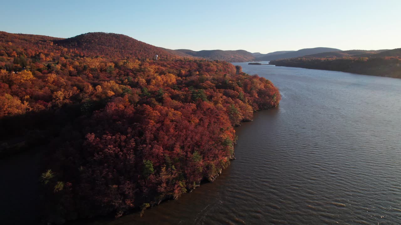 Gorgeous generic nature drone shot. Forest in autumn colors with river and mountains. 4K