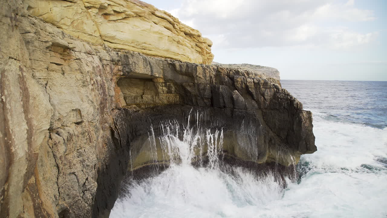espectacular vista panorámica de la costa de las turbulentas y poderosas olas del océano rompiendo en un acantilado rocoso junto al mar en un día soleado, malta, enfoque aéreo