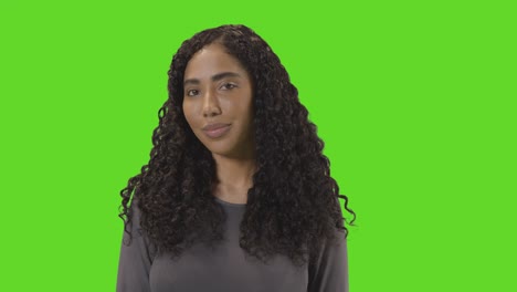 portrait of woman against green screen smiling at camera 1