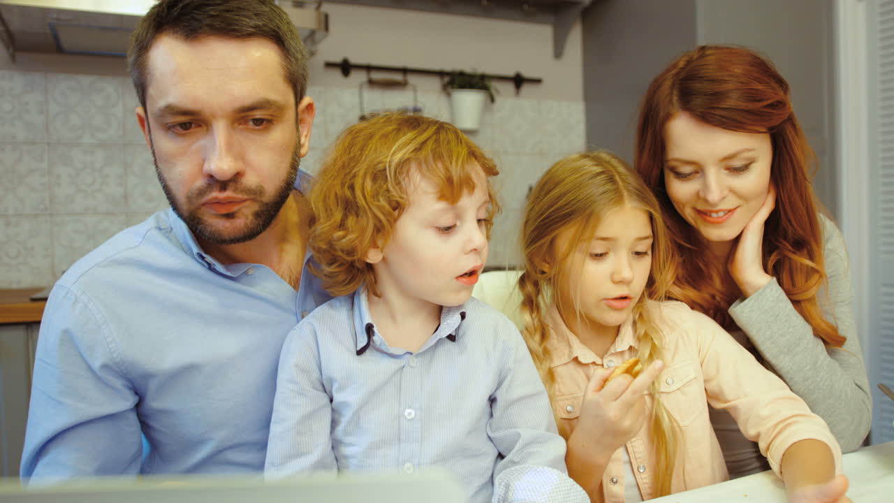 부엌 배경에 태블릿을 사용하여 노트북과 dauther를 사용하여 아침 아버지를 갖는 동안 가족의 초상화