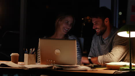 casual colleagues using a laptop at night