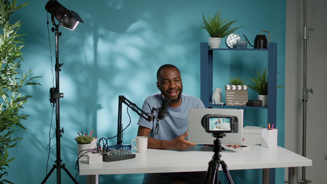 Influencer dei social media che recensisce il laptop sulla fotocamera per il podcast