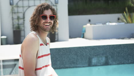 Un-Joven-Caucásico-Disfruta-De-Un-Día-Soleado-Junto-A-La-Piscina,-Con-Espacio-Para-Copiar