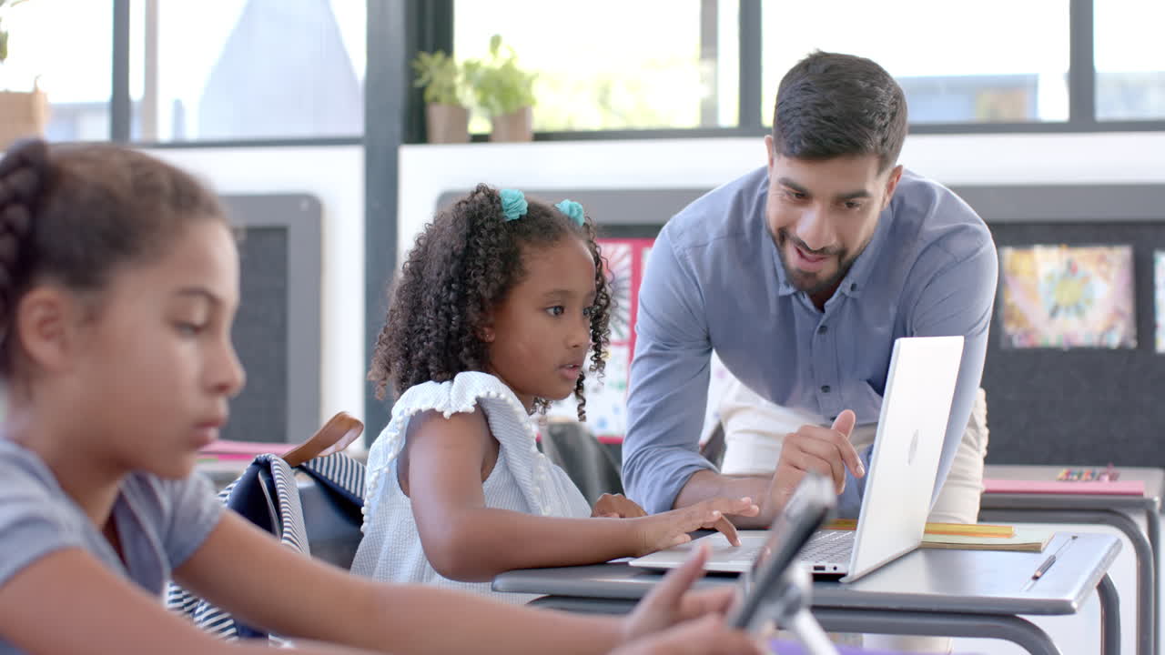 Young Asian man teaches in a school classroom with a laptop