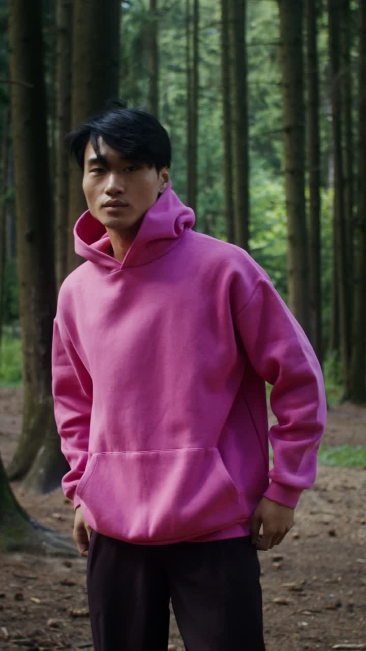 Uomo con felpa rosa nel bosco