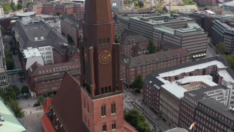 Fliegen-Um-St.-James-Church-Hohe-Turmspitze-Mit-Blick-Auf-Breite-Straßen,-Die-Von-Großen-Backsteingebäuden-Gesäumt-Sind.-Freie-Und-Hansestadt-Hamburg,-Deutschland