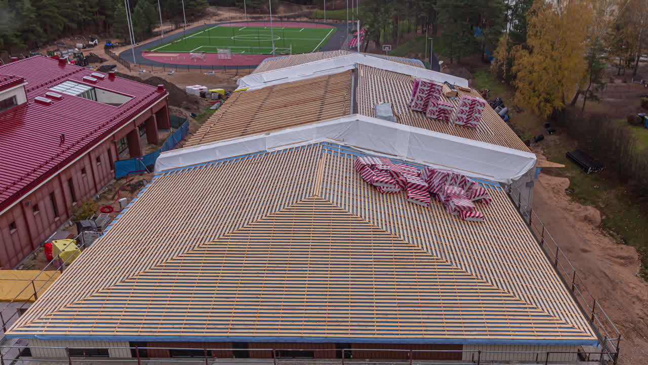 hombres trabajando instalando techos de casas modulares en una comunidad recién construida en un día soleado
