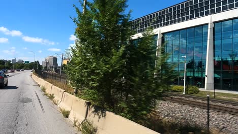 Car-POV-passing-Ottawa-rail-tracks,-modern-buildings,-and-cityscape