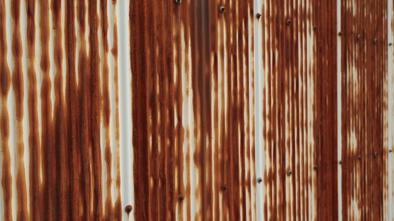 Rusty corrugated metal wall with vertical patterns.