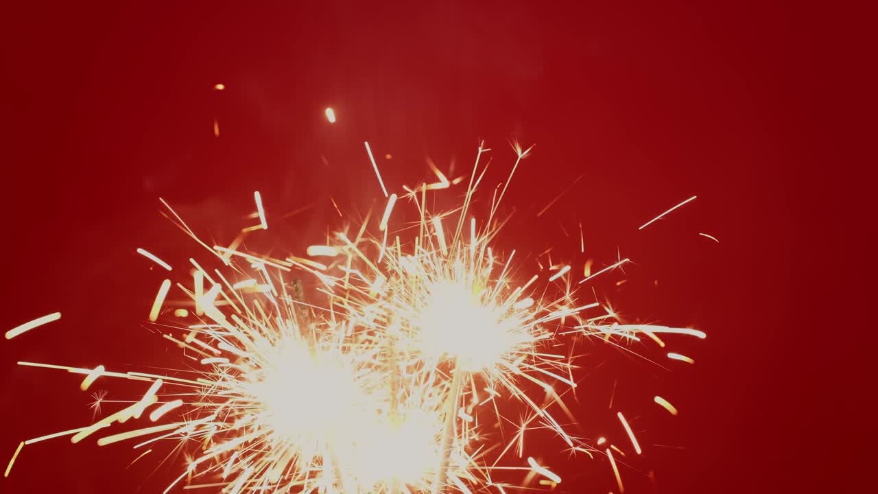 4k. chispas brillantes que queman la luz de navidad sobre un fondo rojo.