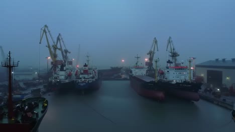 misty harbor scene with cargo ships and cranes under foggy conditions: a gloomy yet captivating maritime landscape capture