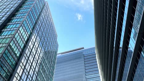 tall modern skyscrapers with glass facades reflecting a clear blue sky