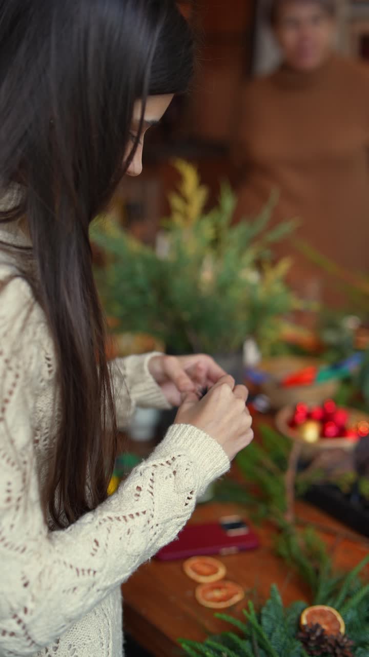 una mujer haciendo una decoración navideña.