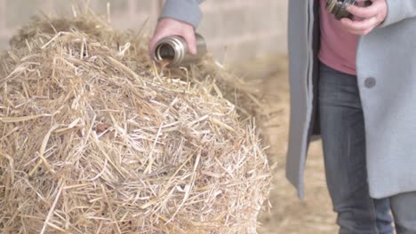 woman taking a break on bale of hay