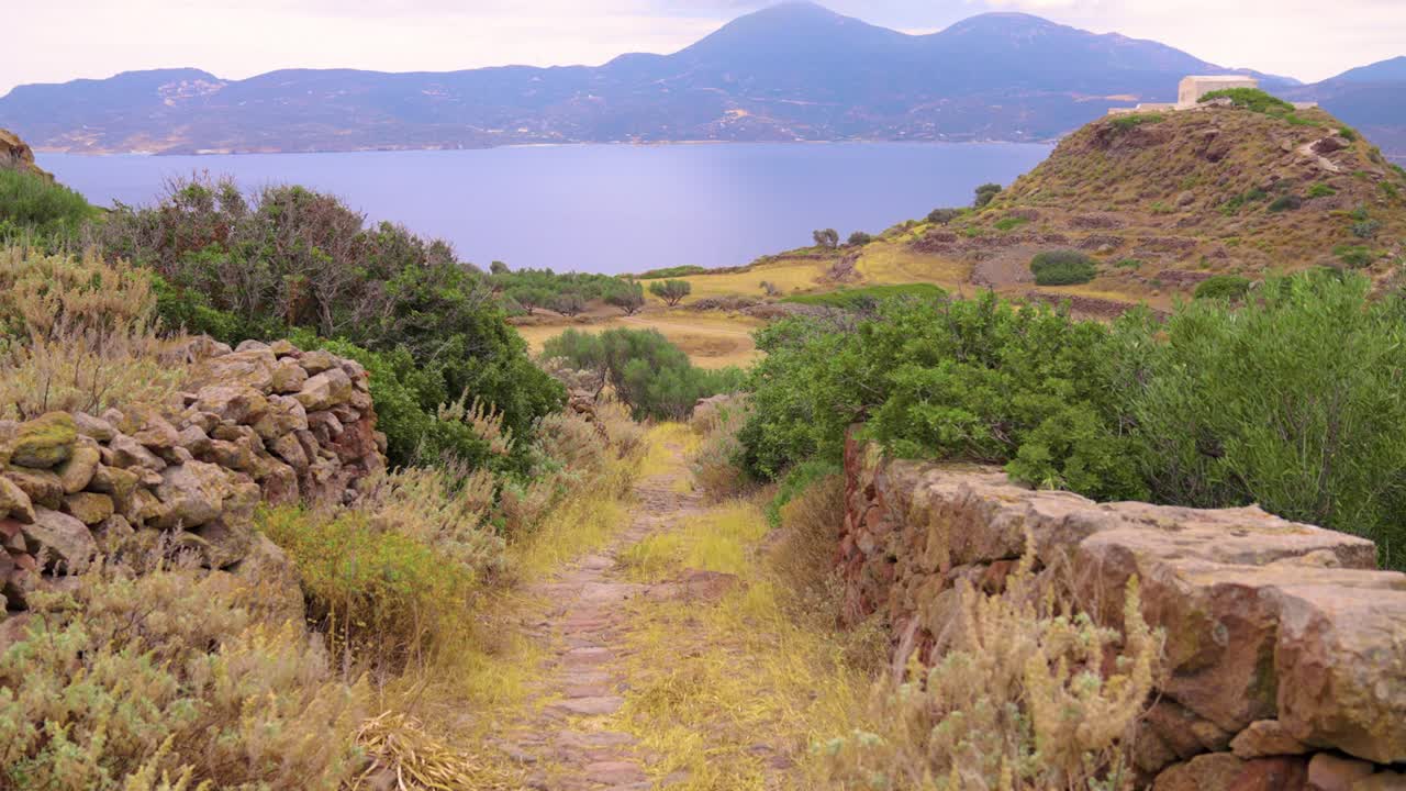 древняя мощенная тропа, ведущая к эгейскому морю, в сельской местности на острове милос, греция