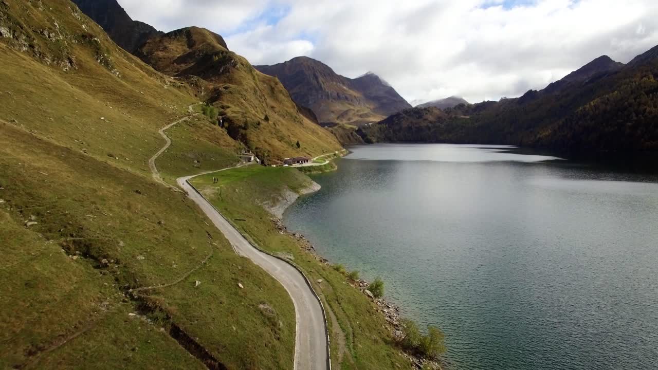vista aérea del lago de montaña en suiza durante el otoño con bosque de pinos de colores, día de otoño nublado con montañas nevadas, lago ritom